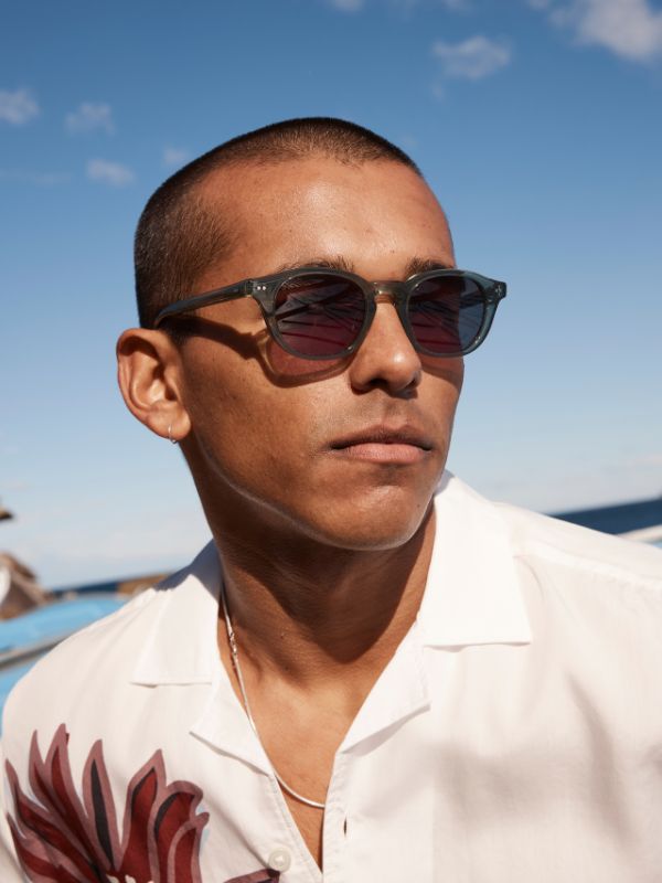 Man wearing Sito Shades Elio sunglasses in Nori green with a clear blue sky background