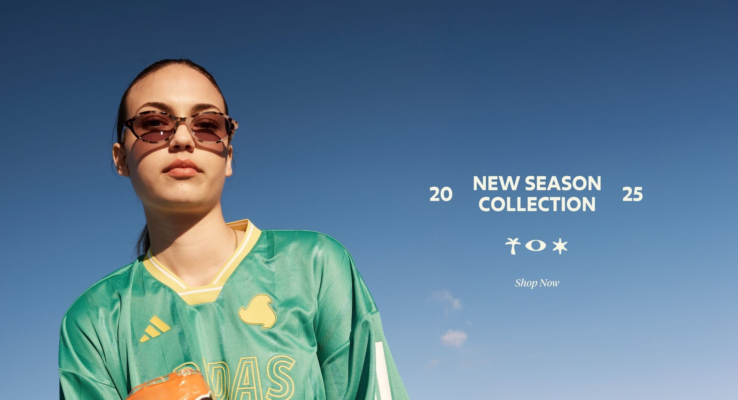 Person wearing a green sports jersey with sunglasses against a clear blue sky, promoting Sito Shades 'New Season Collection'.